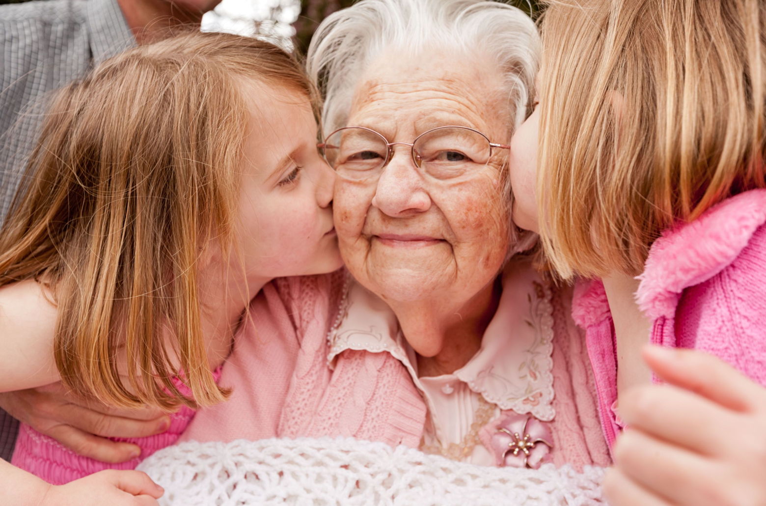 Grandma getting kisses from grandchildren