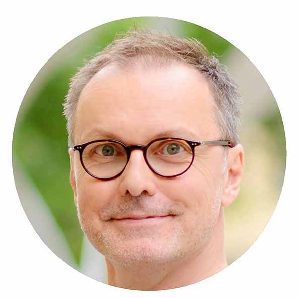 Mężczyzna w okularach z krótkimi siwymi włosami