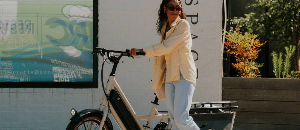 a woman standing next to a Specialized Globe Haul electric cargo bike