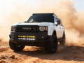white toyota land cruiser with led light bars behind the grille for off roading