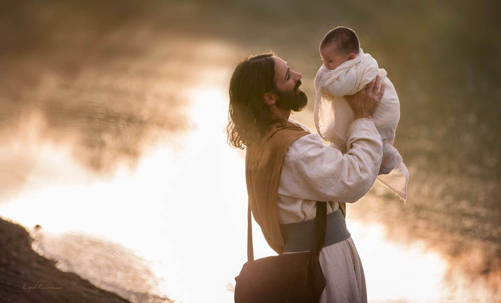 Jesus holding an infant wrapped in swaddling clothes.