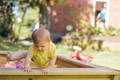 Baby exiting a sandbox.