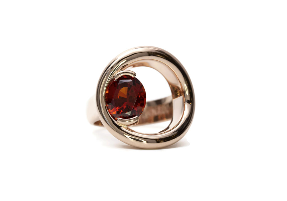 Design men's ring with garnet and round opening on the hand