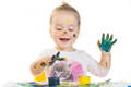 Little girl is messy while fingerpainting. 