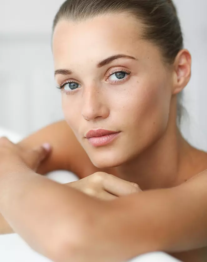 Une belle femme pose dans sa baignoire.