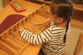 Little girl playing with a wooden Spindle box.