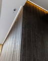 Integrated LED strip lighting highlighting dark timber wall