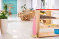 A modern Montessori classroom with wooden desks and shelves. 