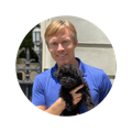 Image of veterinarian Dr. Patrick Mahaney holding a terrier dog and smiling