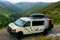 the frost river van on a dirt road looking over the mountains of rocky mountain national park