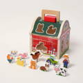 Wooden farmhouse shape-sorting toy with farm animals, a farmer, and a tractor.