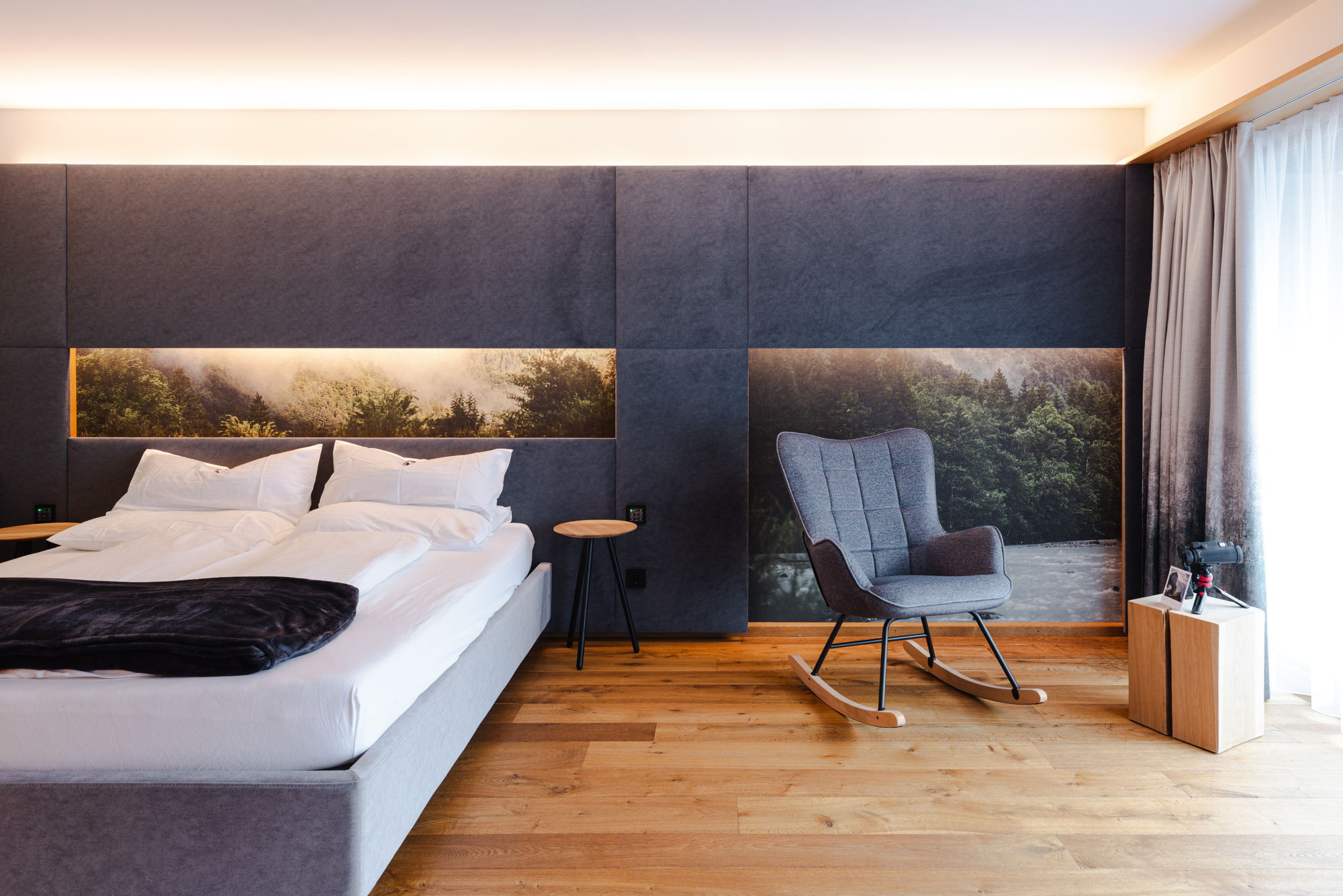 Sonnensuite mit Doppelbett und Schaukelstuhl im Bregenzerwald Hotel