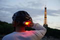 Cycliste avec casque vélo lumineux devant la Tour Eiffel