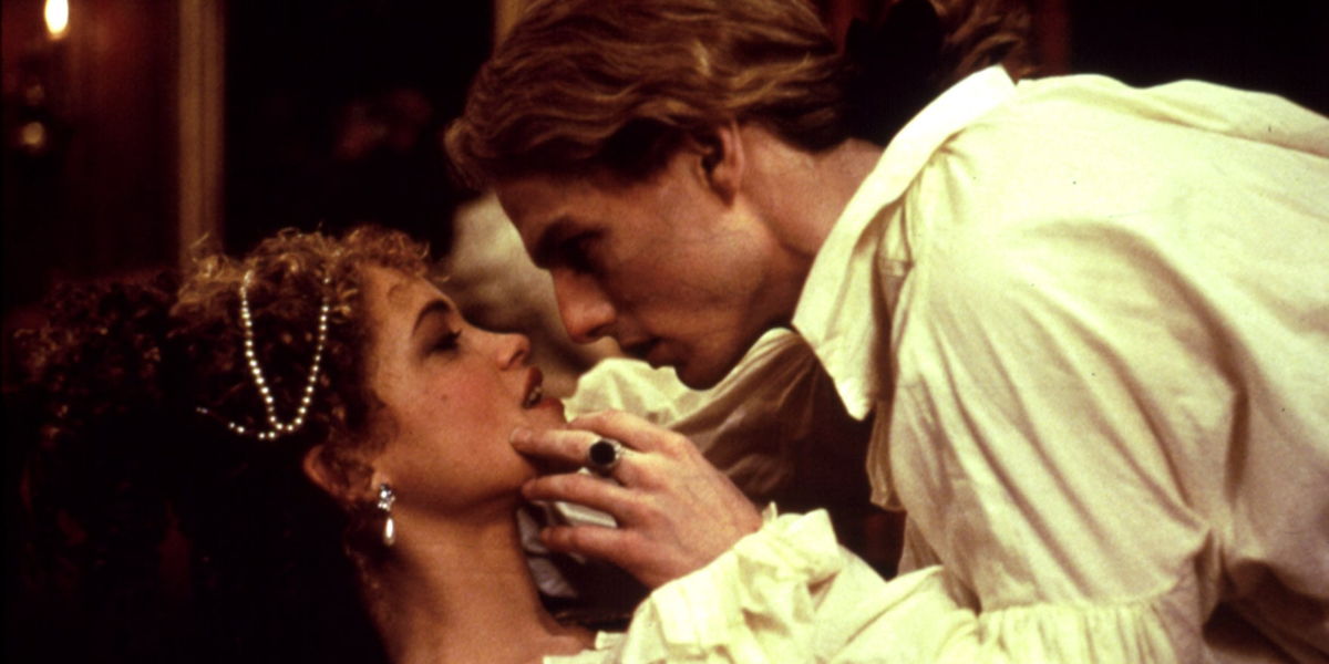 Lestat with his hand on Claudia's chin closing in for a kiss while they are lying down.