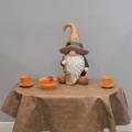 a brown vinyl oval tablecloth with some fall decorations on it