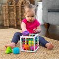 Little girl sitting on a rug and playing with Montessori Shape Blocks.