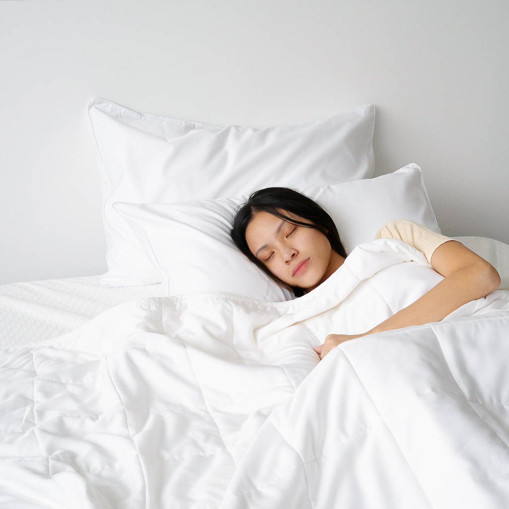 Woman sleeping while laying on TENCEL duvet and bed sheets