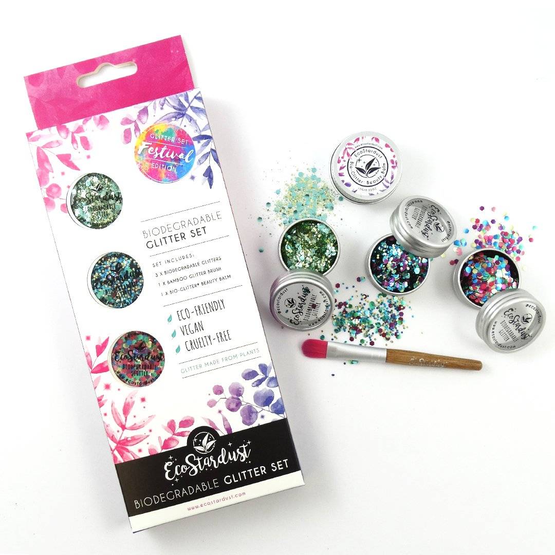 Image shows our festival glitter set with 3x multicoloured glitter blends. Image shows the box, as well as the pots of glitter opened with some glitter spilled over the edge onto the table, as well as our vegan bamboo application brush.