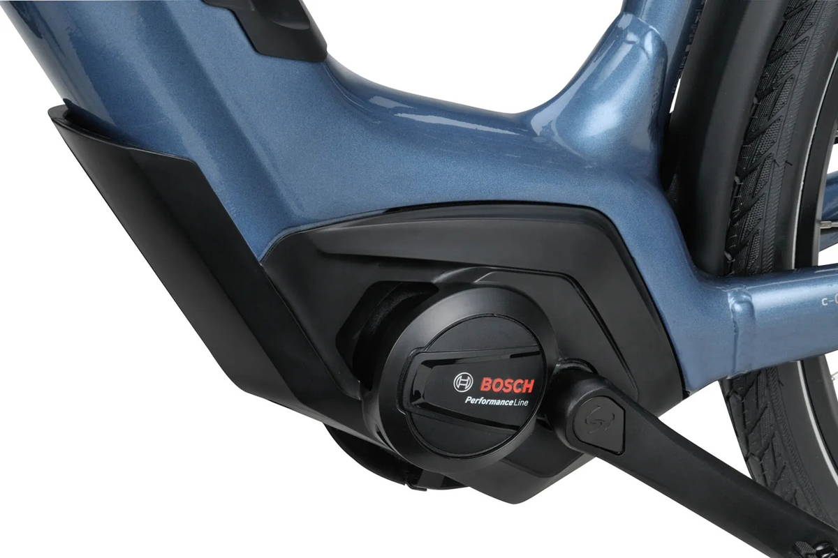 Gros plan d'un moteur central Bosch Performance Line monté au pédalier d'un vélo électrique au cadre bleu