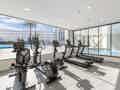 Helles, modernes Fitnessstudio mit Laufbändern, Fahrrädern und Crosstrainern sowie Blick auf den Innen- und Außenpool durch große Fenster.