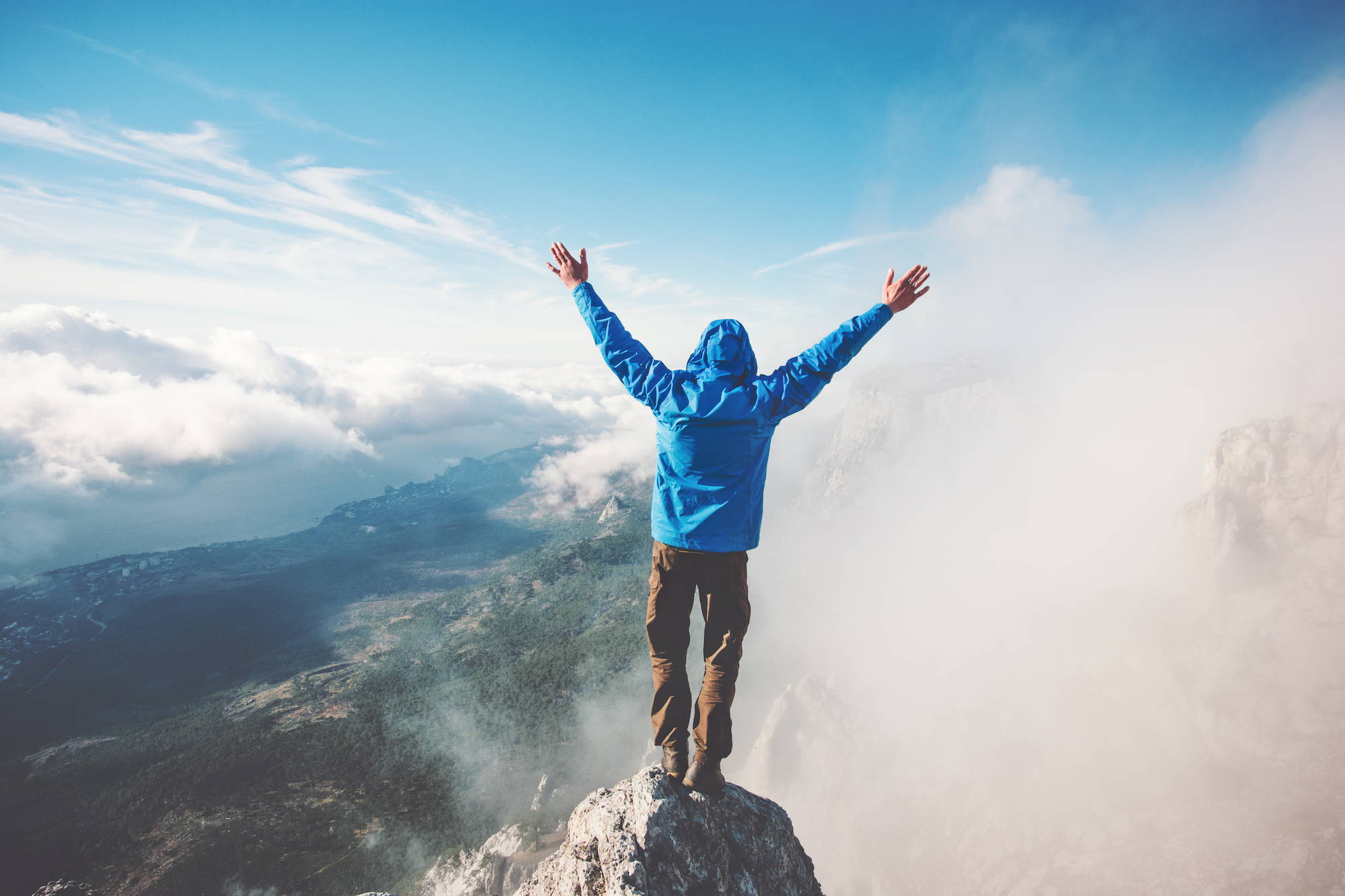 Magnesium in health supports wellbeing - man on top of mountain