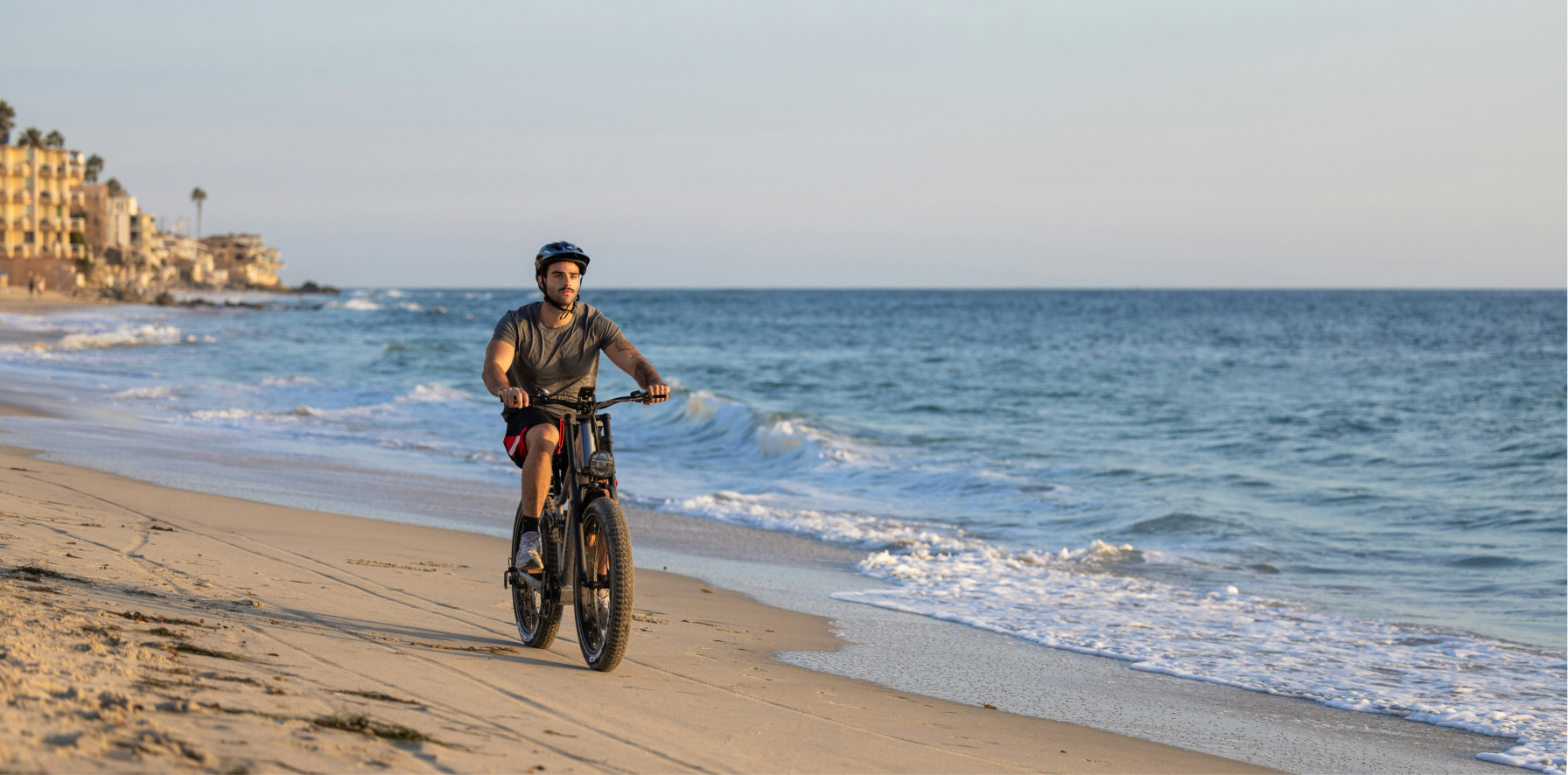 hombre usando una ebike nueva por la playa