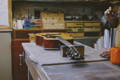 An acoustic guitar laid on a work table for repairs.