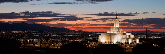 Panoramic photo of the Draper temple glowing in the night sky.