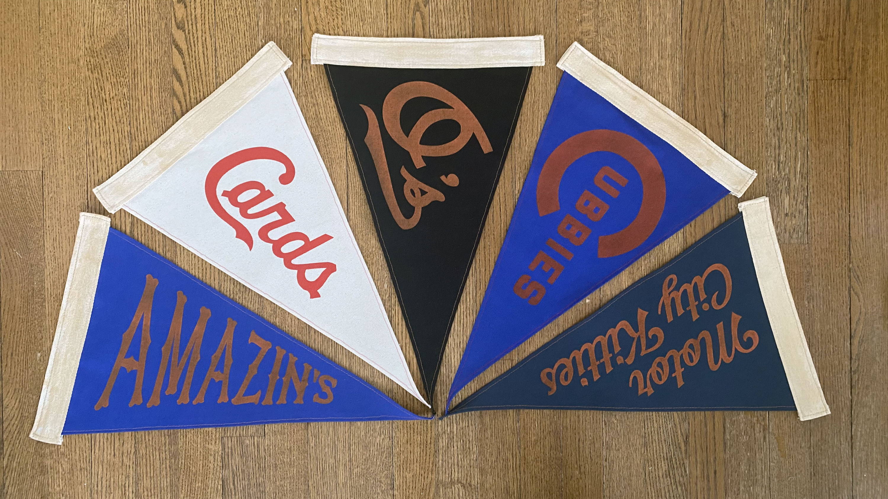 Semicircle of Amazin's, Cards, O's, Cubbies and Motor City Kitties pennants.
