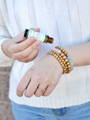 woman using essential roll on bottle on diffuser bracelets 