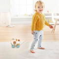 Toddler playing with the Montessori Roaring Roller pulling toy.