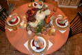 round tablecloth on a table with pumpkins and flowers decoration