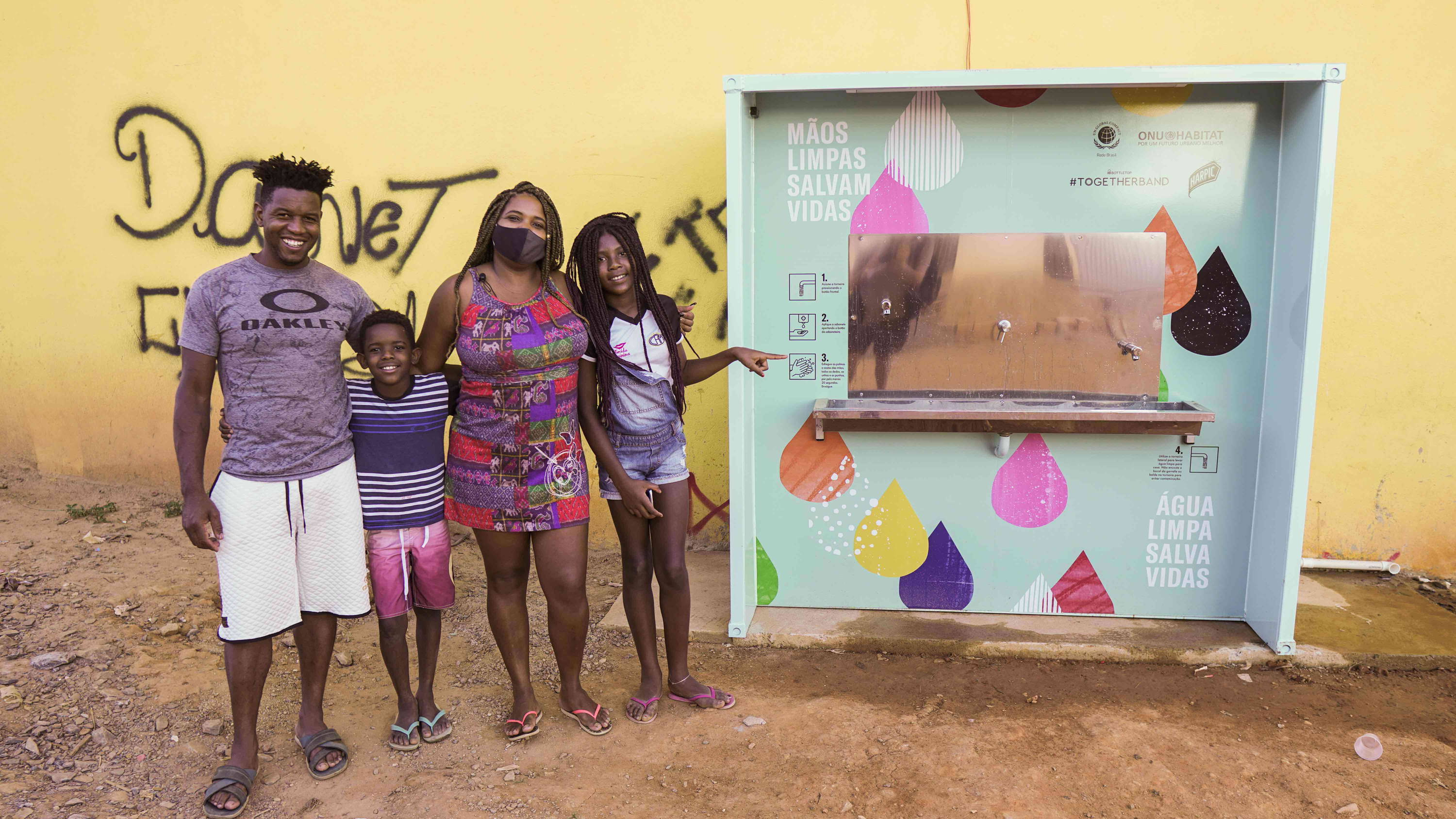 Family with our water station in Brazil