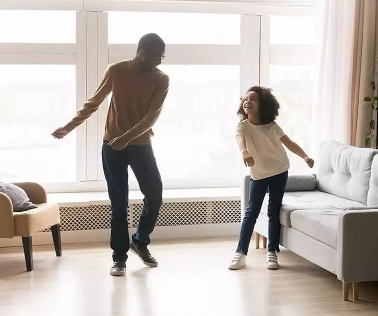 father and daughter dancing the floss in living room