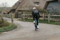 Cycliste en costume sur son vélo, image floue