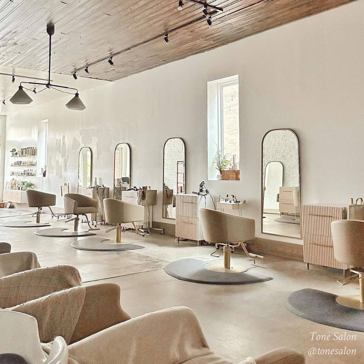 inside of a salon with many chairs, mirrors, and hairstyling tools