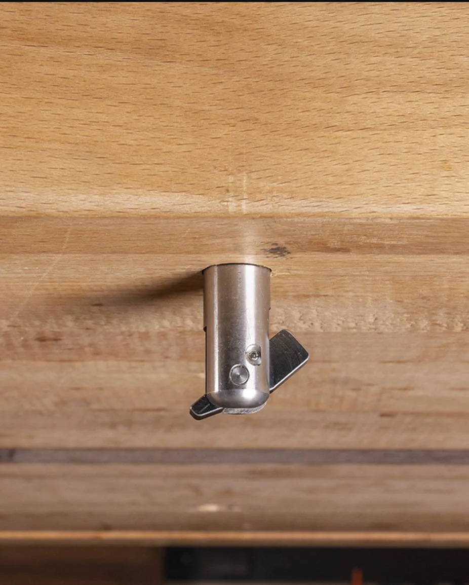 Insert the Toolless Installation Mechanism of the Compass AH 3 arch hold down through the workbench hole.