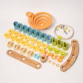 Flat lay of Montessori-inspired bamboo marble run components, including spiral ramps, colorful cylindrical connectors, wooden tracks, marbles, and a rope ring, all designed for hands-on STEM play and construction.