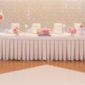 table skirt of pink color with natural flowers over a large table