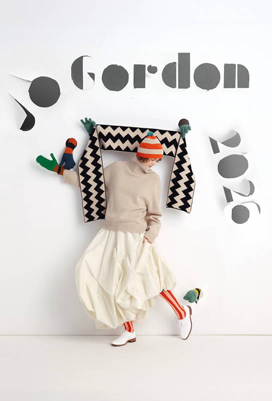 model peers out from behind a wall of colourful Jo Gordon scarves