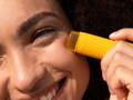model applying the spf stick on her face