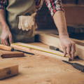 Craftsman measuring wood to cut for furniture