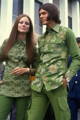 A couple in the 60s wearing green cannabis themed clothing