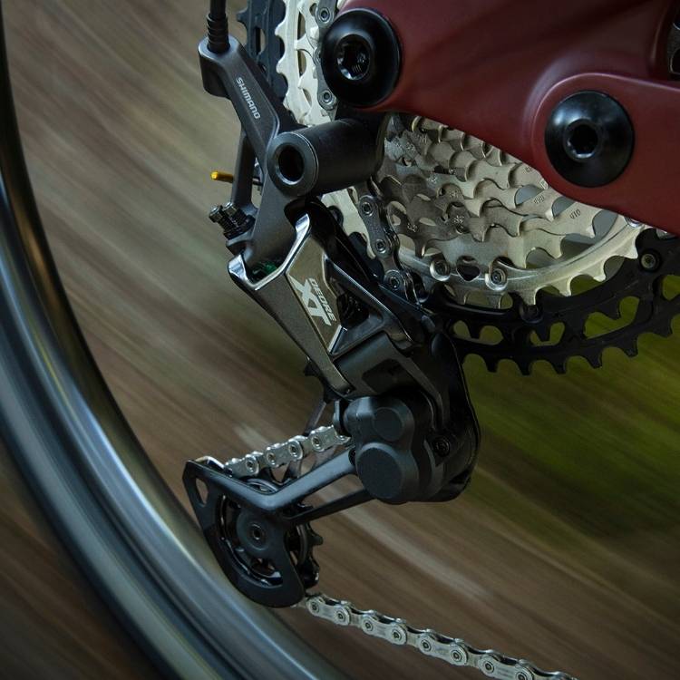 Vététiste en action sur un sentier avec un VTT équipé d'une transmission Shimano XT