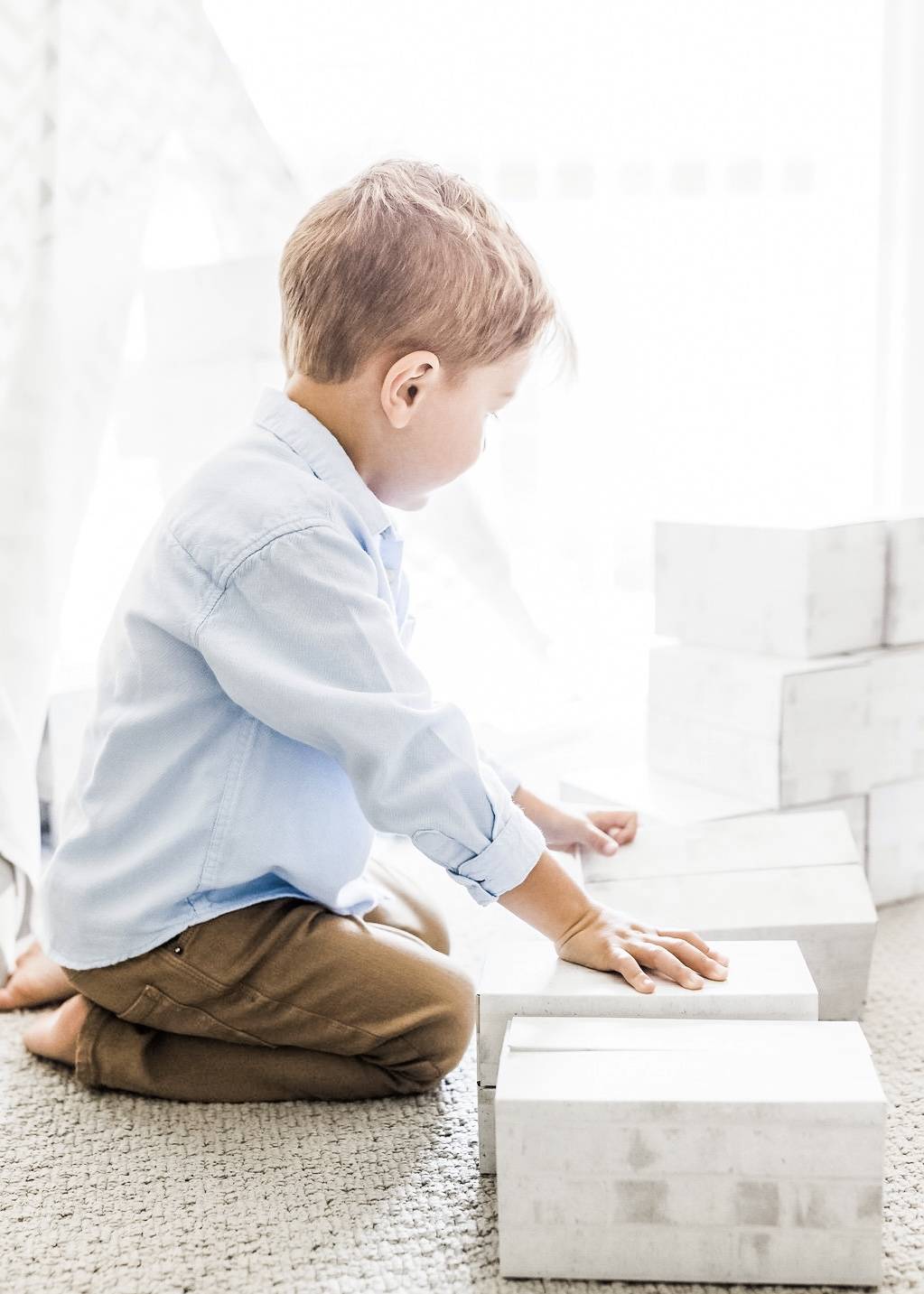 Boy-with-white-building-blocks-in-playroom
