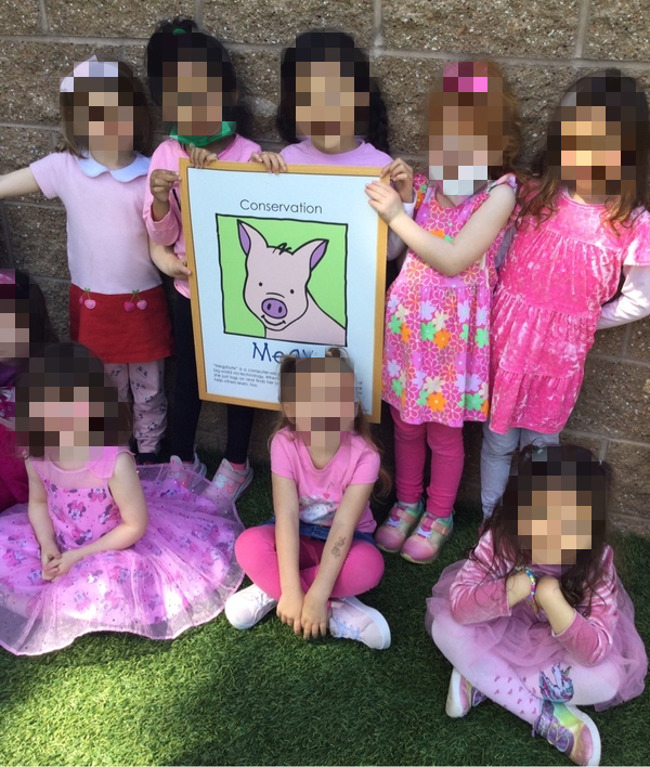students wearing pink holding a megy the pig sign 