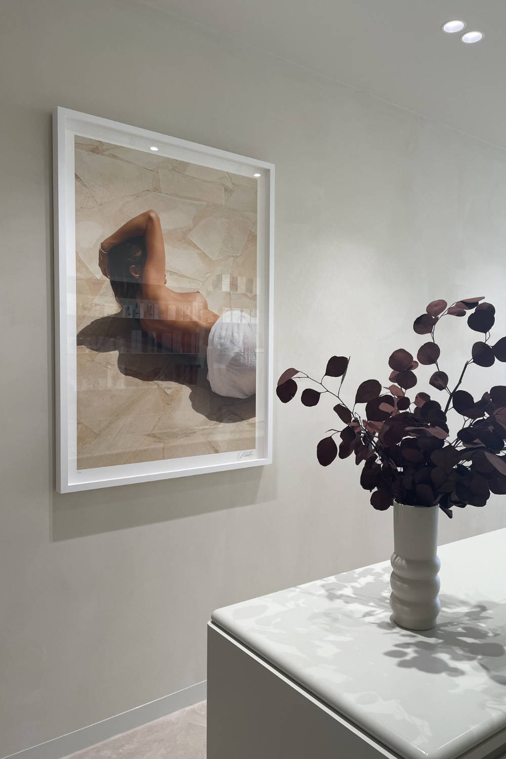 'Dreamer' by Dina Broadhurst - A photographic print of a girl, nude laying on tiles, framed and styled in a beautician reception space.