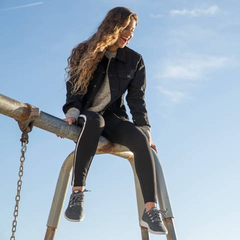 A girl sits on top of a swing set
