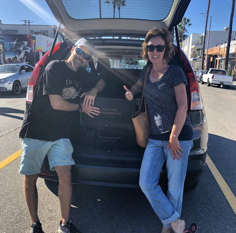 Happy customer with Keetsa mattress in their car. Ready to take their mattress.