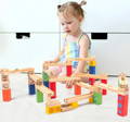 Little girl playing with the Montessori Wooden Marble Run toy.